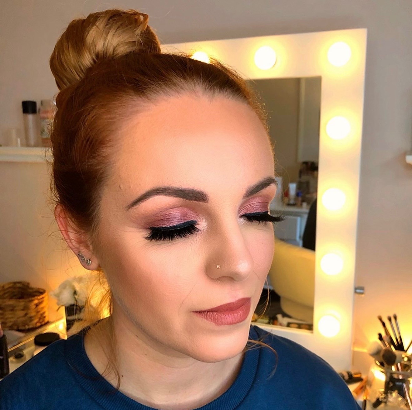 Client looking down to show rosy eyeshadow and defined lashes