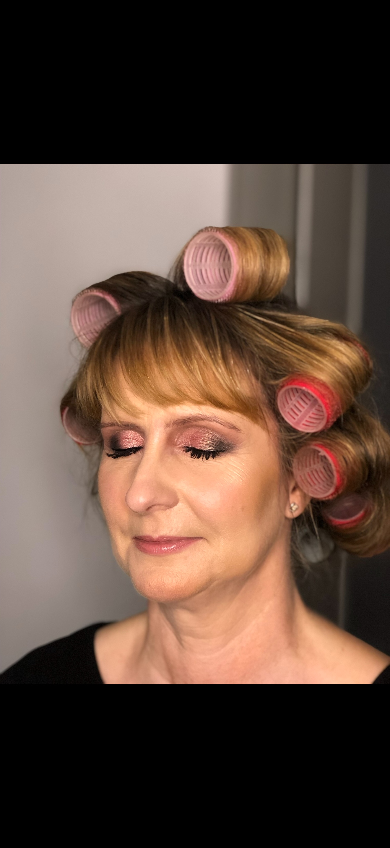 Client with pink shimmer eyeshadow and a glossy pink lip